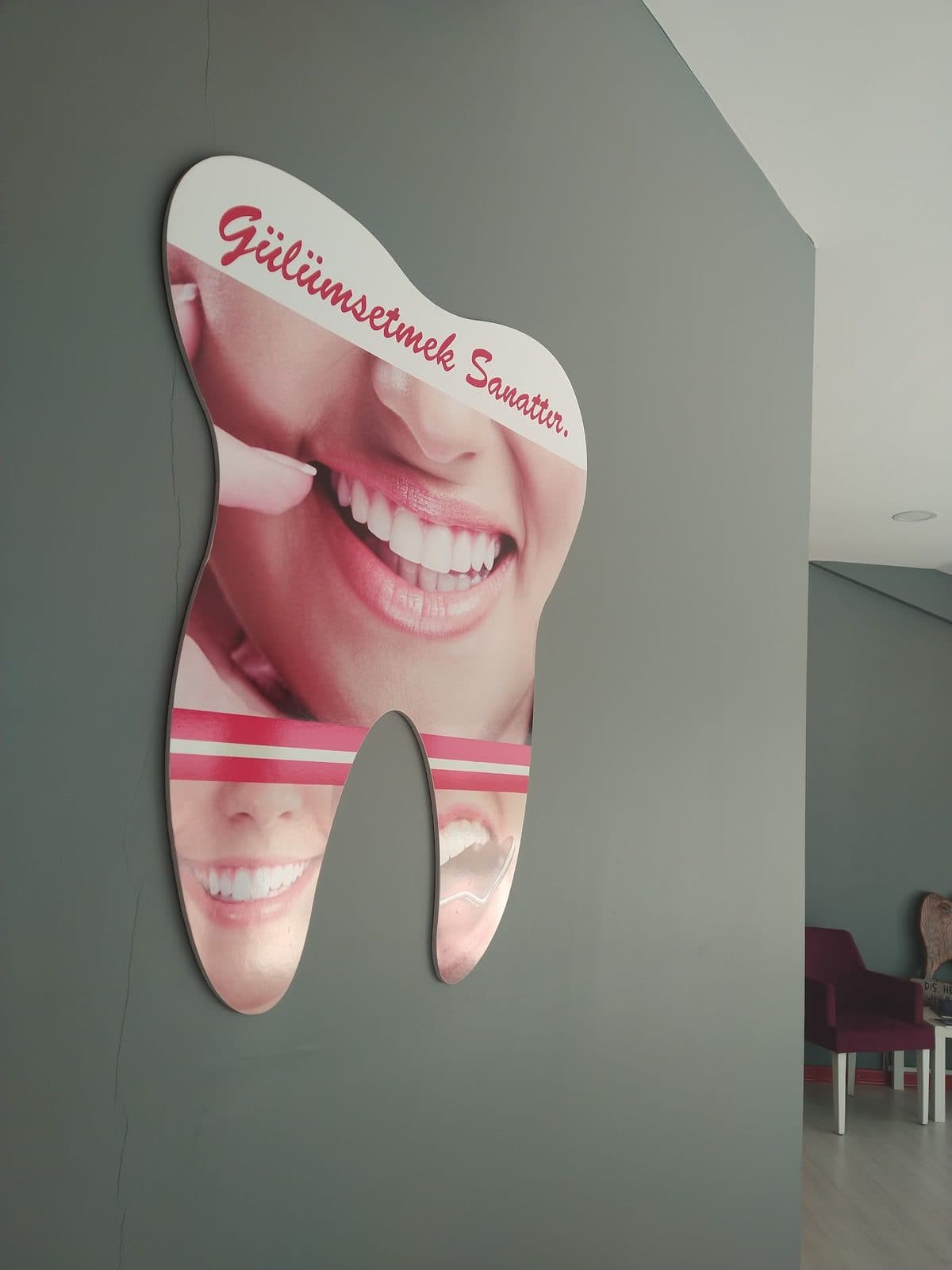 Klinik duvarındaki “Gülümsetmek Sanattır” panosu